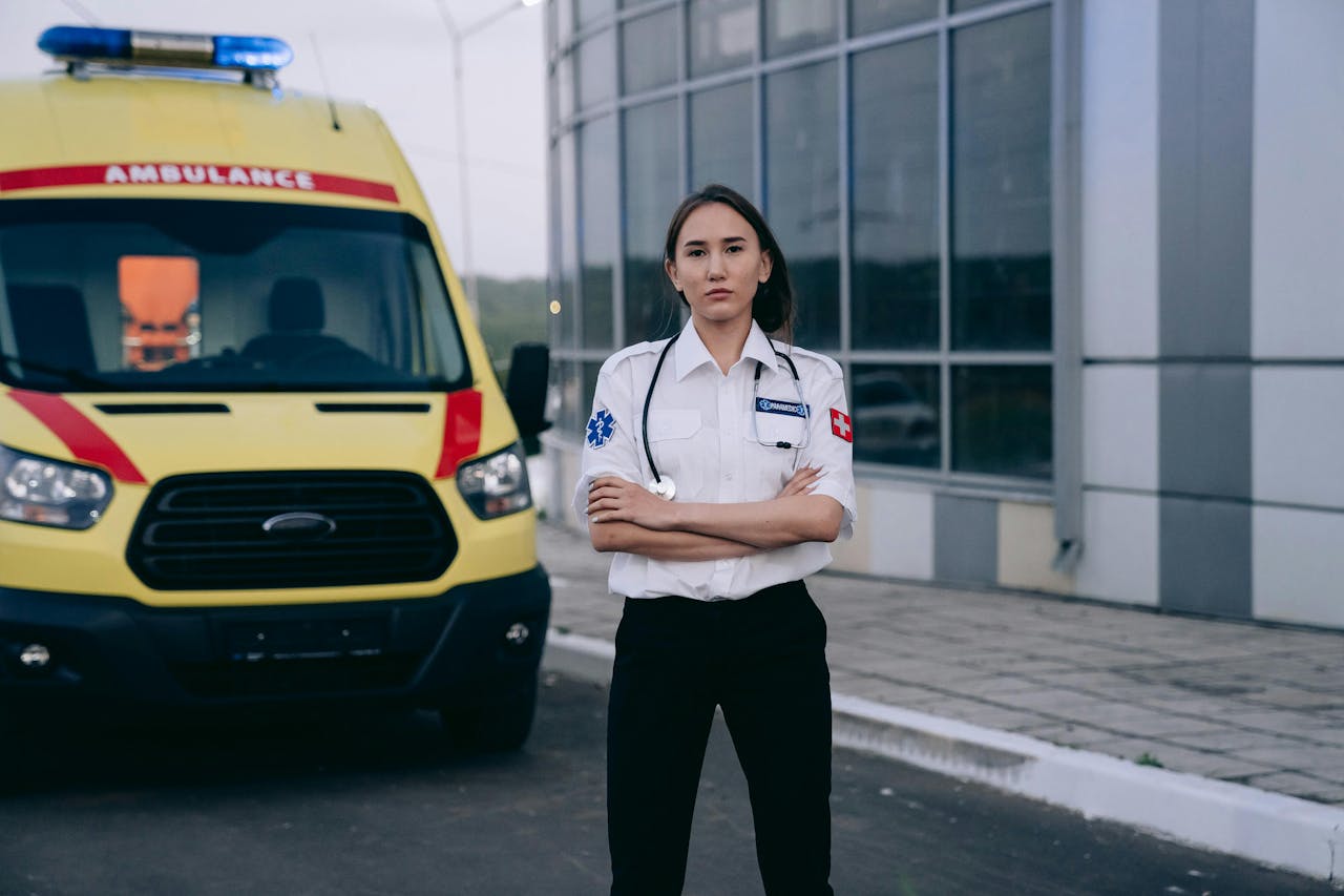 A female paramedic standing confidently by an ambulance, showcasing healthcare professionalism.